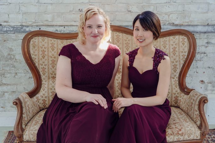 Mari Inoue und Katharina Sames sitzen in Abendkleidern auf einer Couch